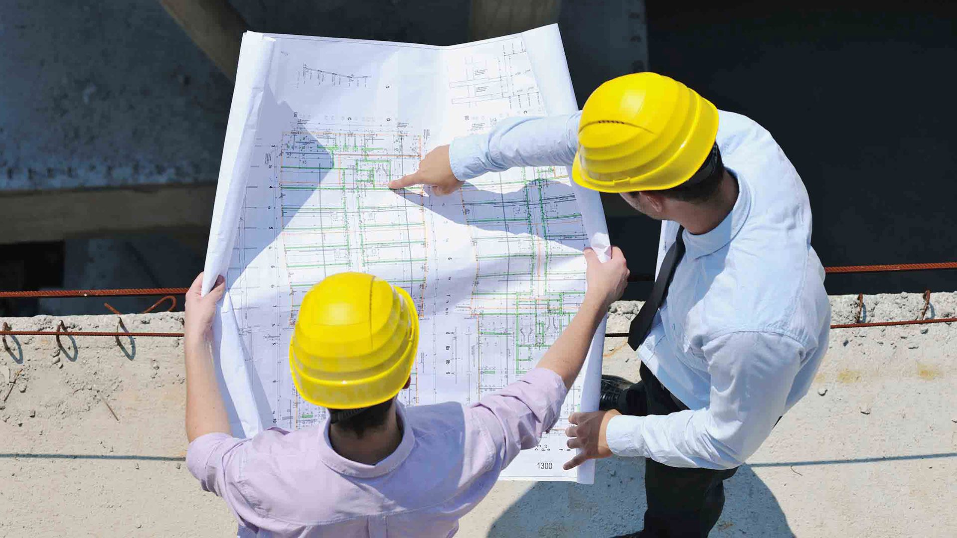 Two men in hard hats looking at a plan.