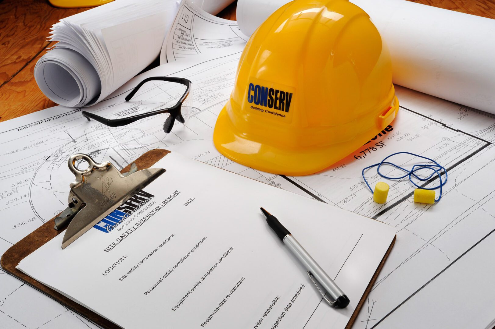 A construction worker 's hard hat sits on top of some papers.
